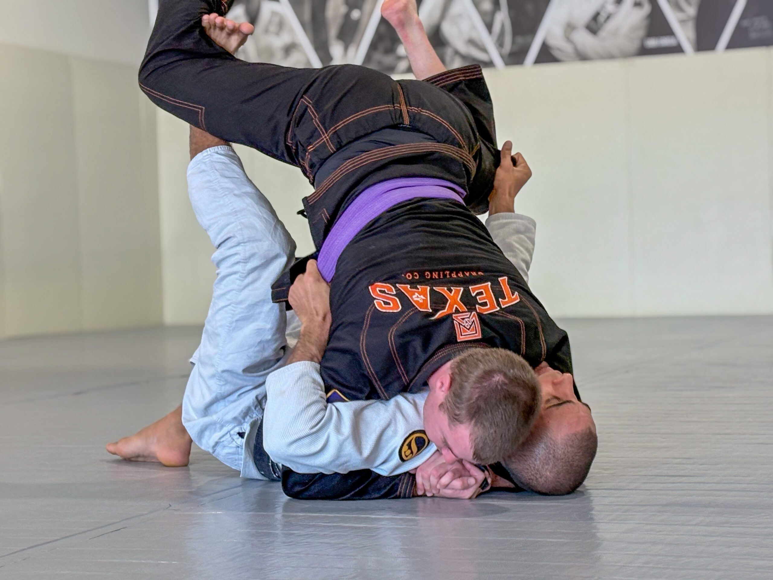 Adult BJJ student passing guard into mount during a positional drilling round