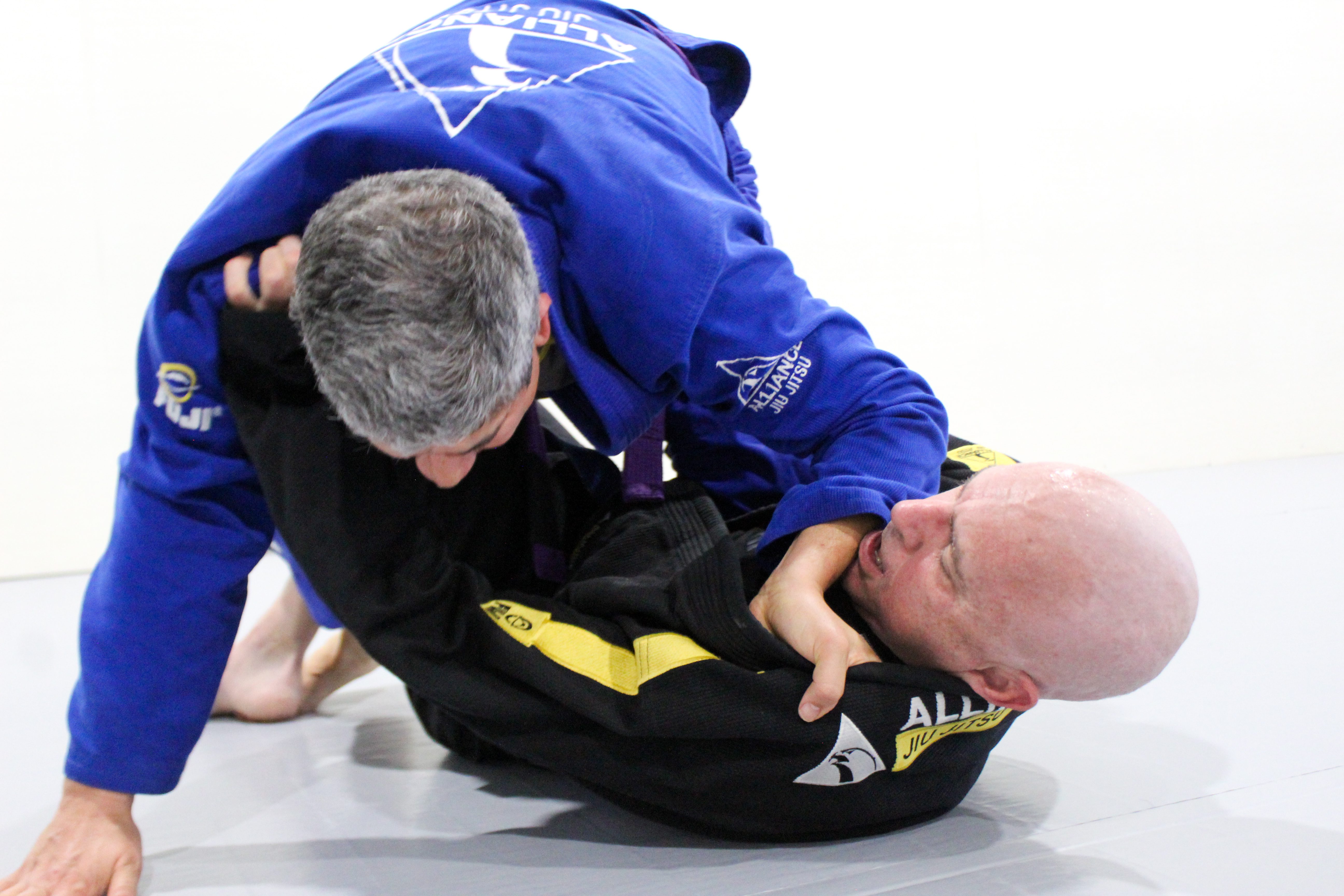 Blue belt applying pressure from top position during grappling