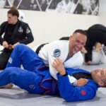 Two adults sparring in side control during jiu-jitsu class