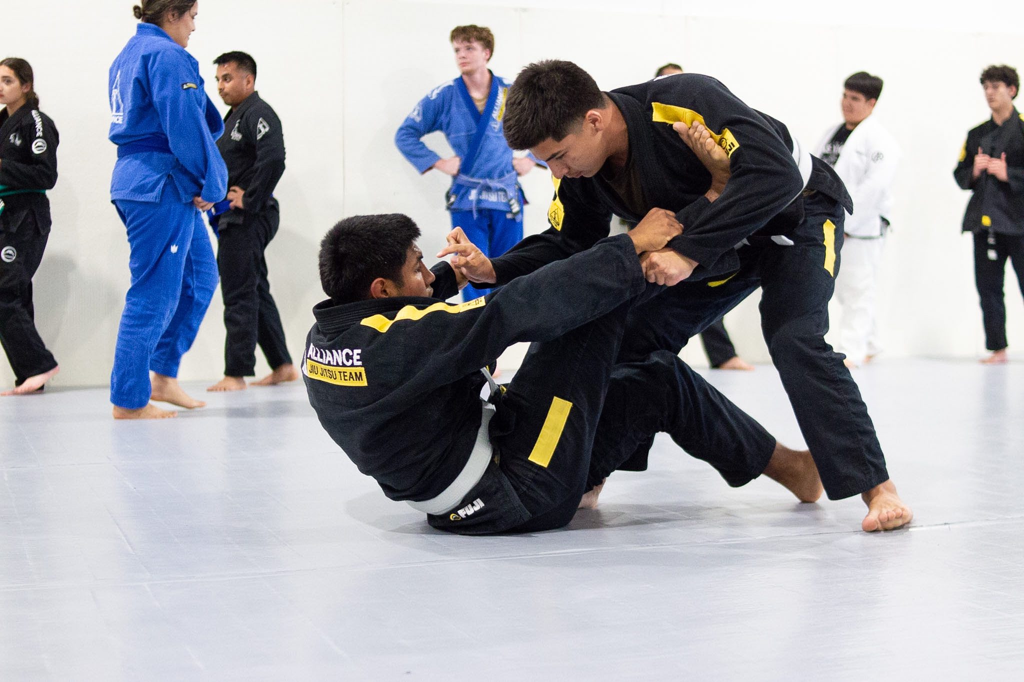 Two grapplers working a guard pass during live jiu-jitsu sparring