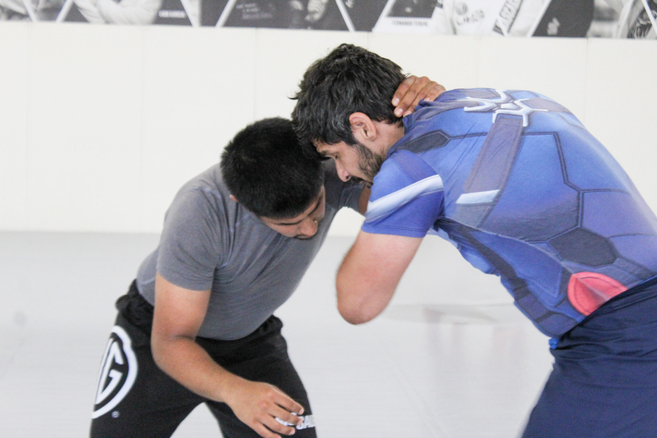 Adult No-Gi grapplers in a stand-up clinch on the main mat