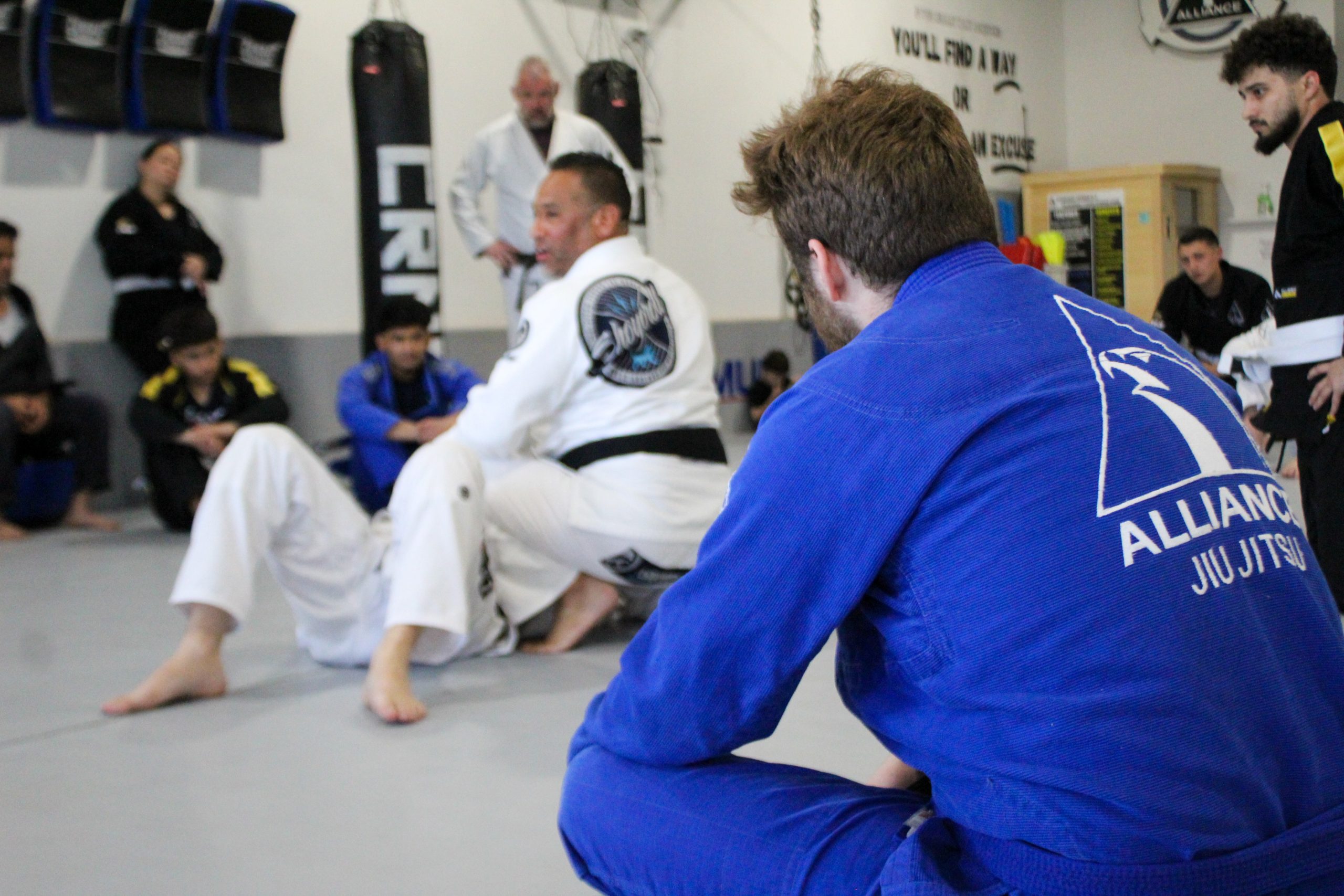 Black belt instructor breaking down a fundamentals technique for a new jiu-jitsu student