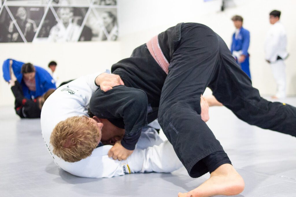 Grappler executing a half guard sweep during adult Brazilian jiu-jitsu class in Houston 77075