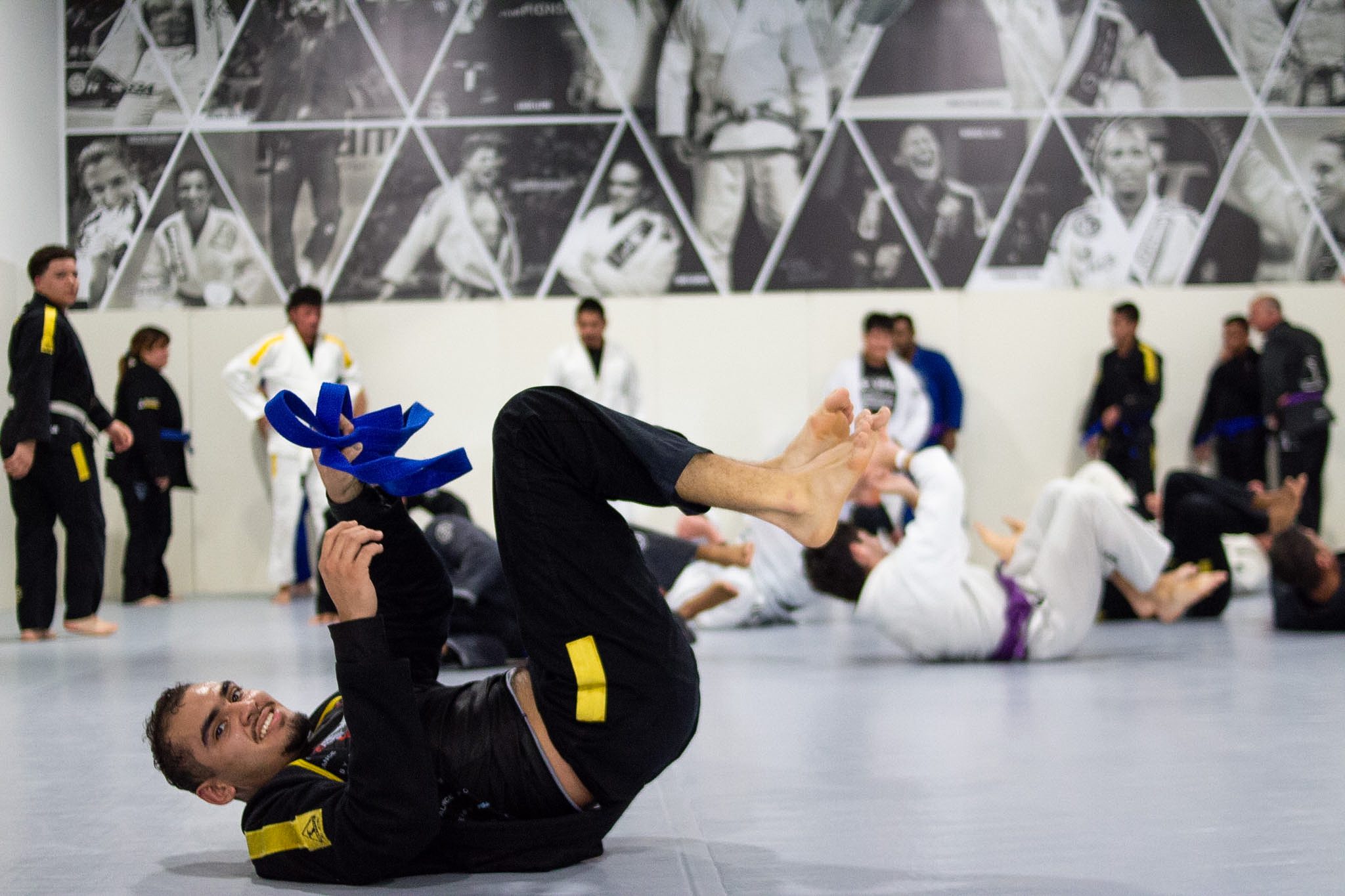 Grappler playing inverted guard with training belts during drilling
