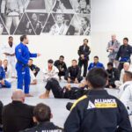 Black belt instructor addressing seated students during a jiu-jitsu seminar at Alliance BJJ Houston