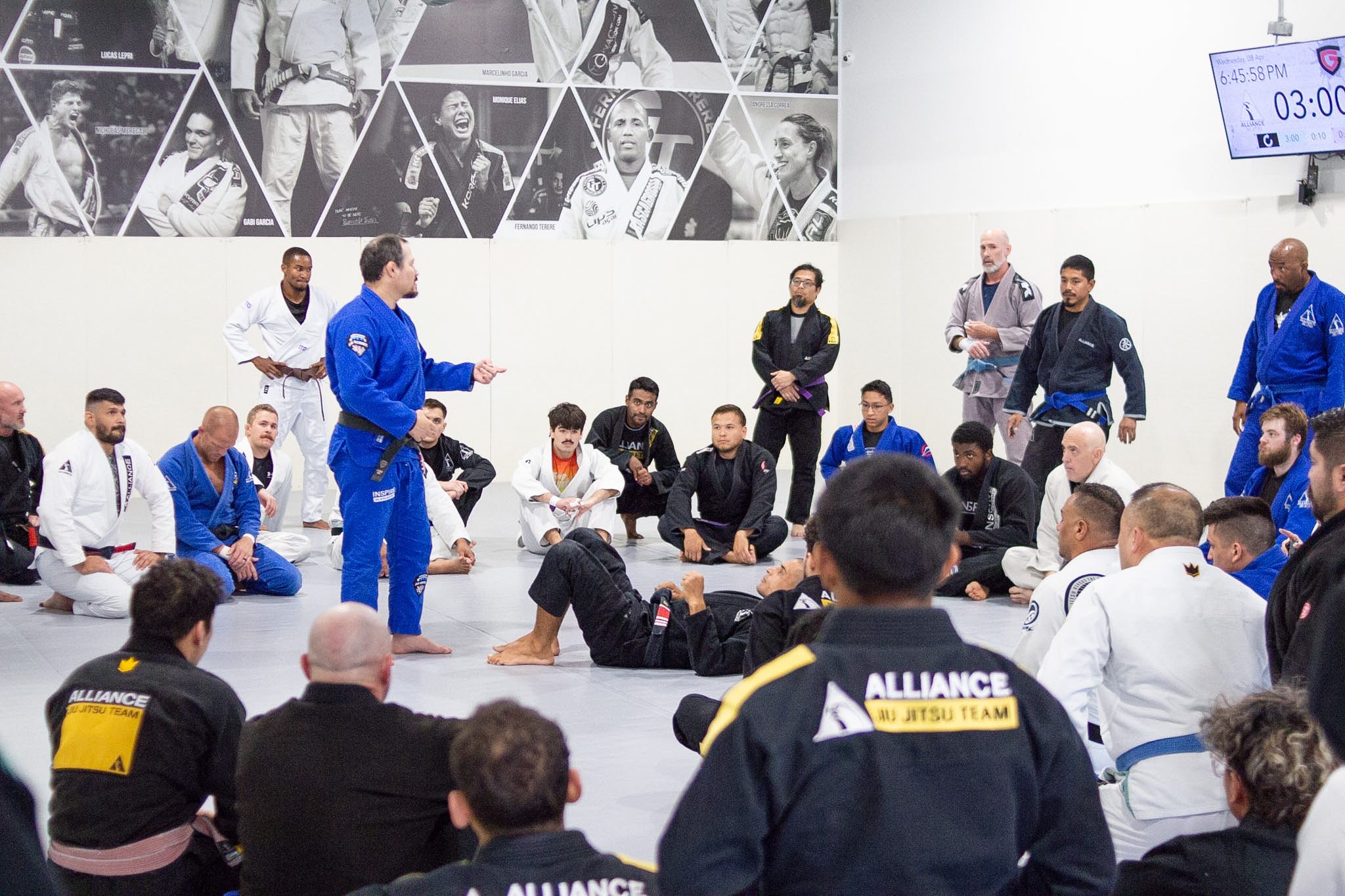 Black belt instructor addressing seated students during a jiu-jitsu seminar at Alliance BJJ Houston