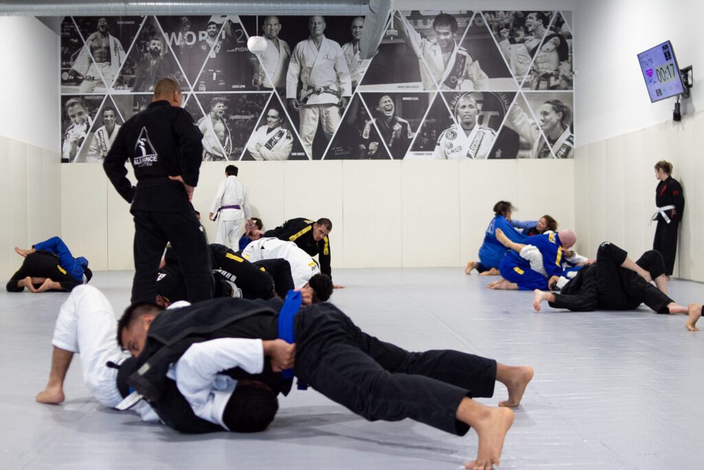 Adult BJJ class warming up and drilling fundamentals on the mat in Pearland