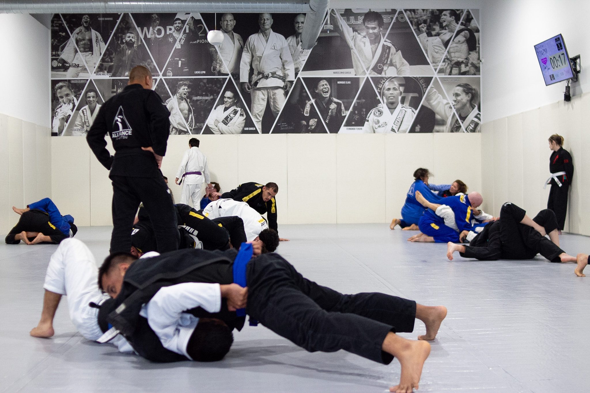 Adult BJJ class warming up and drilling on the mat