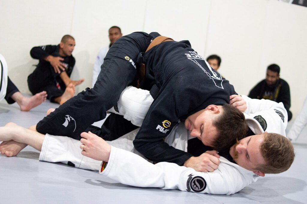 Full team group photo on the mat after a black belt promotion at Alliance BJJ Houston