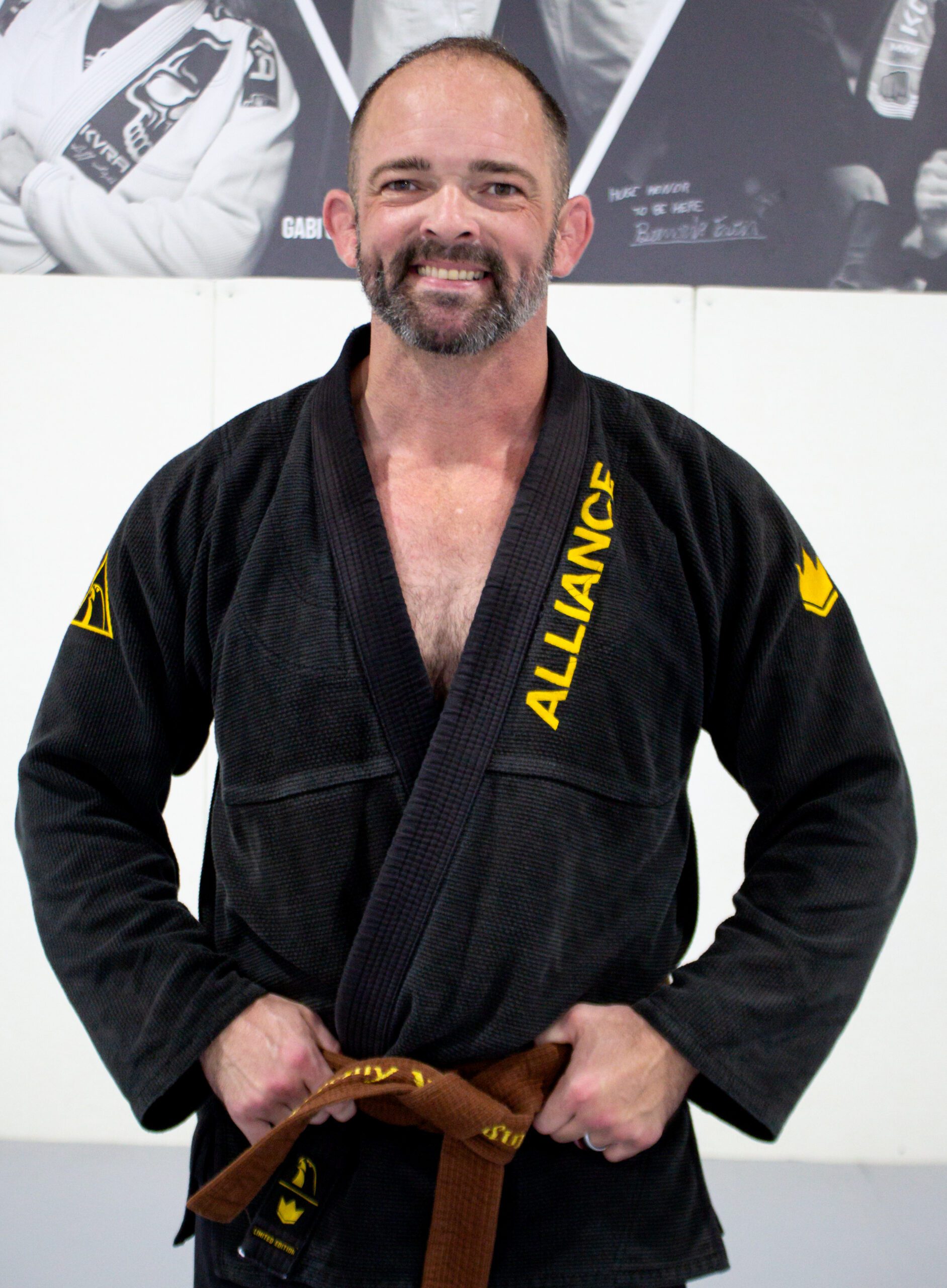 Coach Jeremy in a black Alliance gi wearing a brown belt at our Houston academy