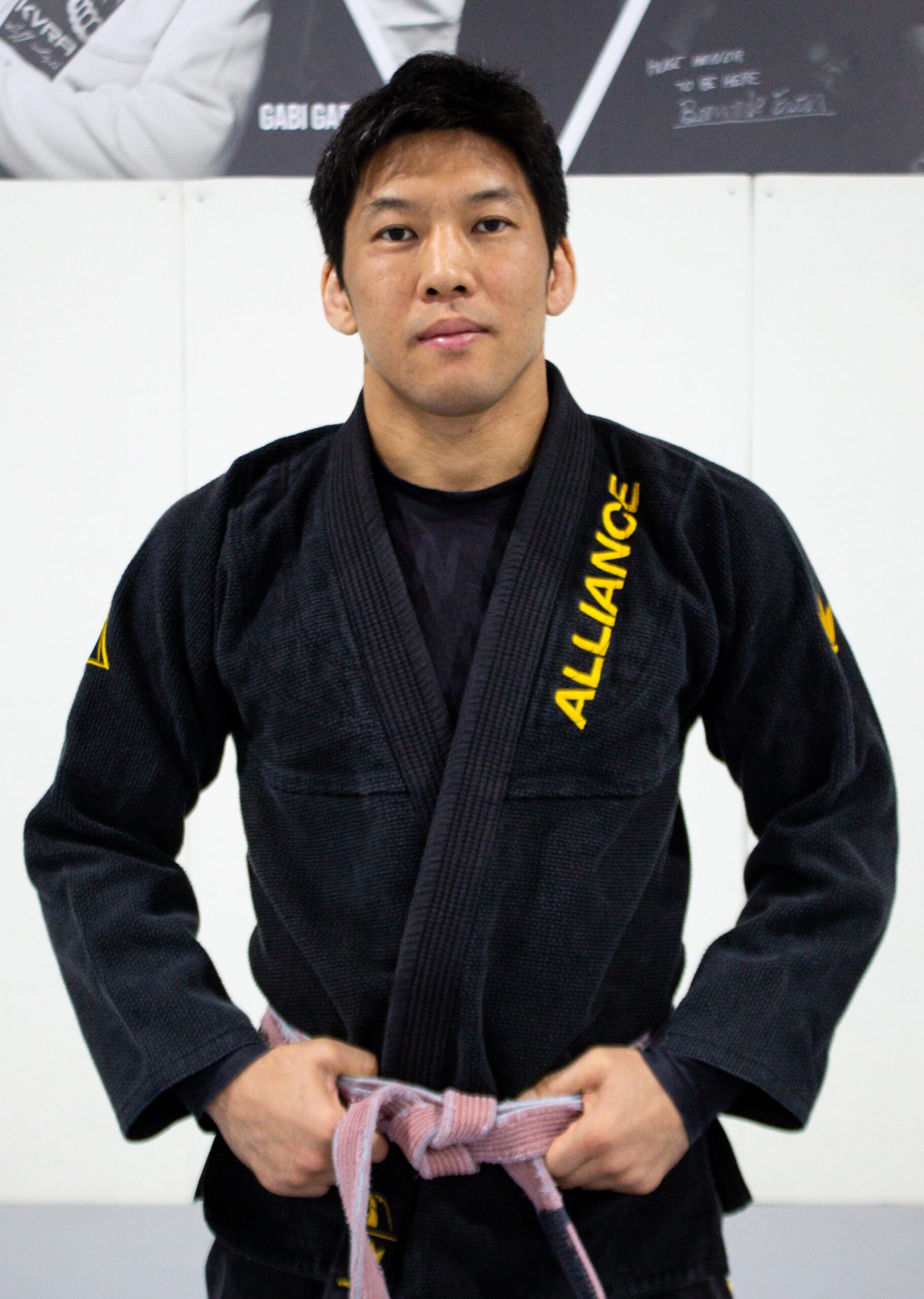 Coach Yuta in a black Alliance gi with a brown belt at our south Houston gym