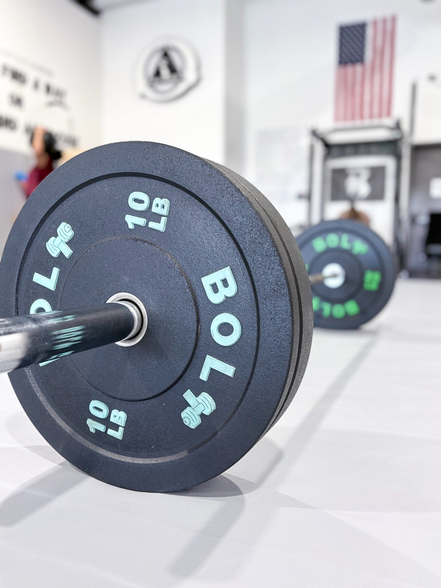 Loaded barbell with bumper plates ready for a Fit Camp strength workout