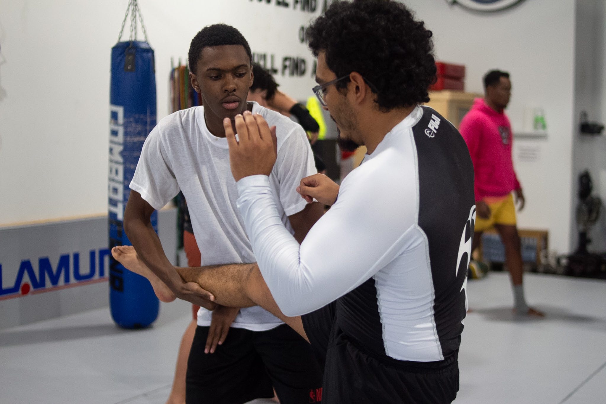 Two students practicing a kickboxing technique drill with partner arm control