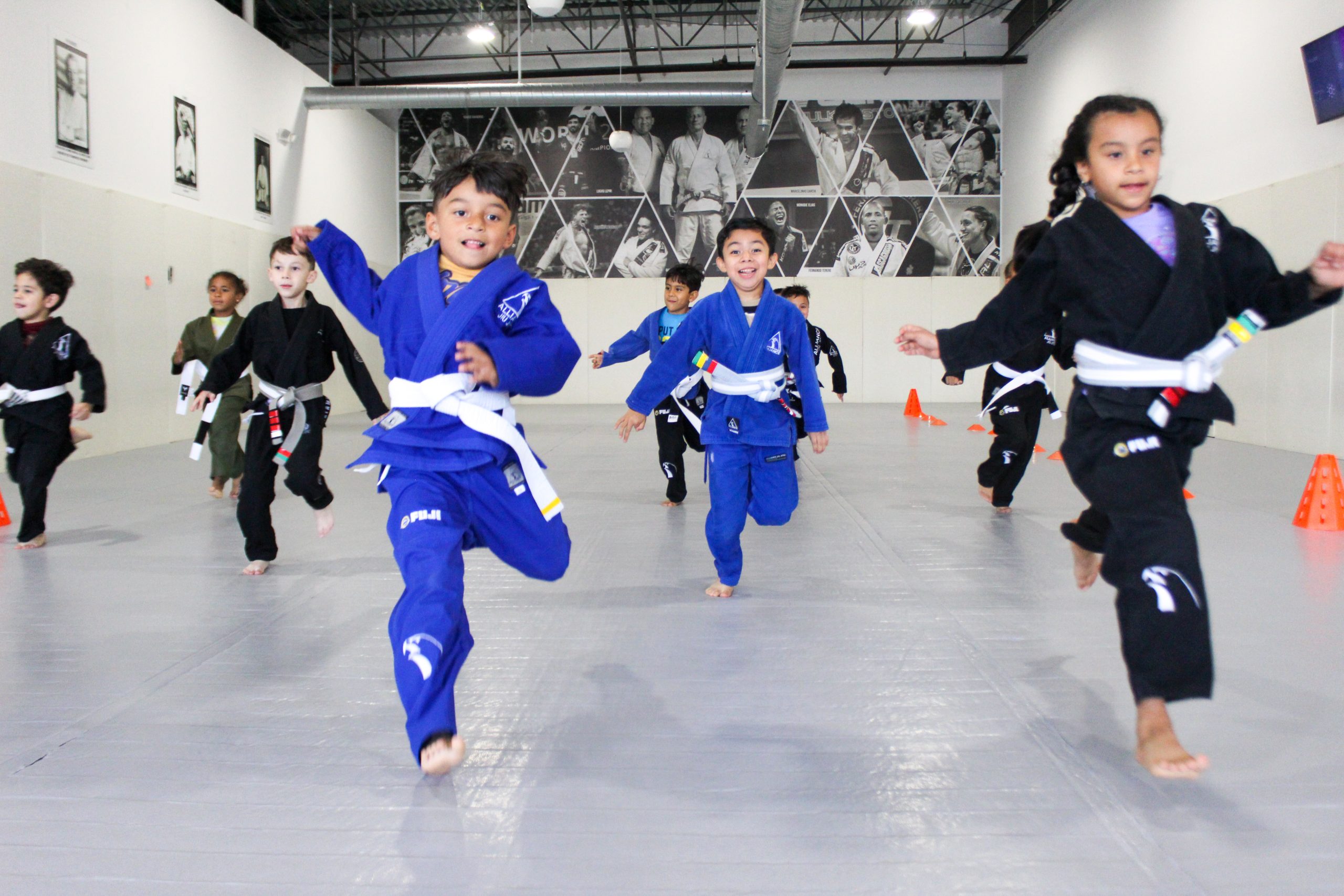 Children warming up in blue and black gis at a kids jiu-jitsu class in Pearland, TX