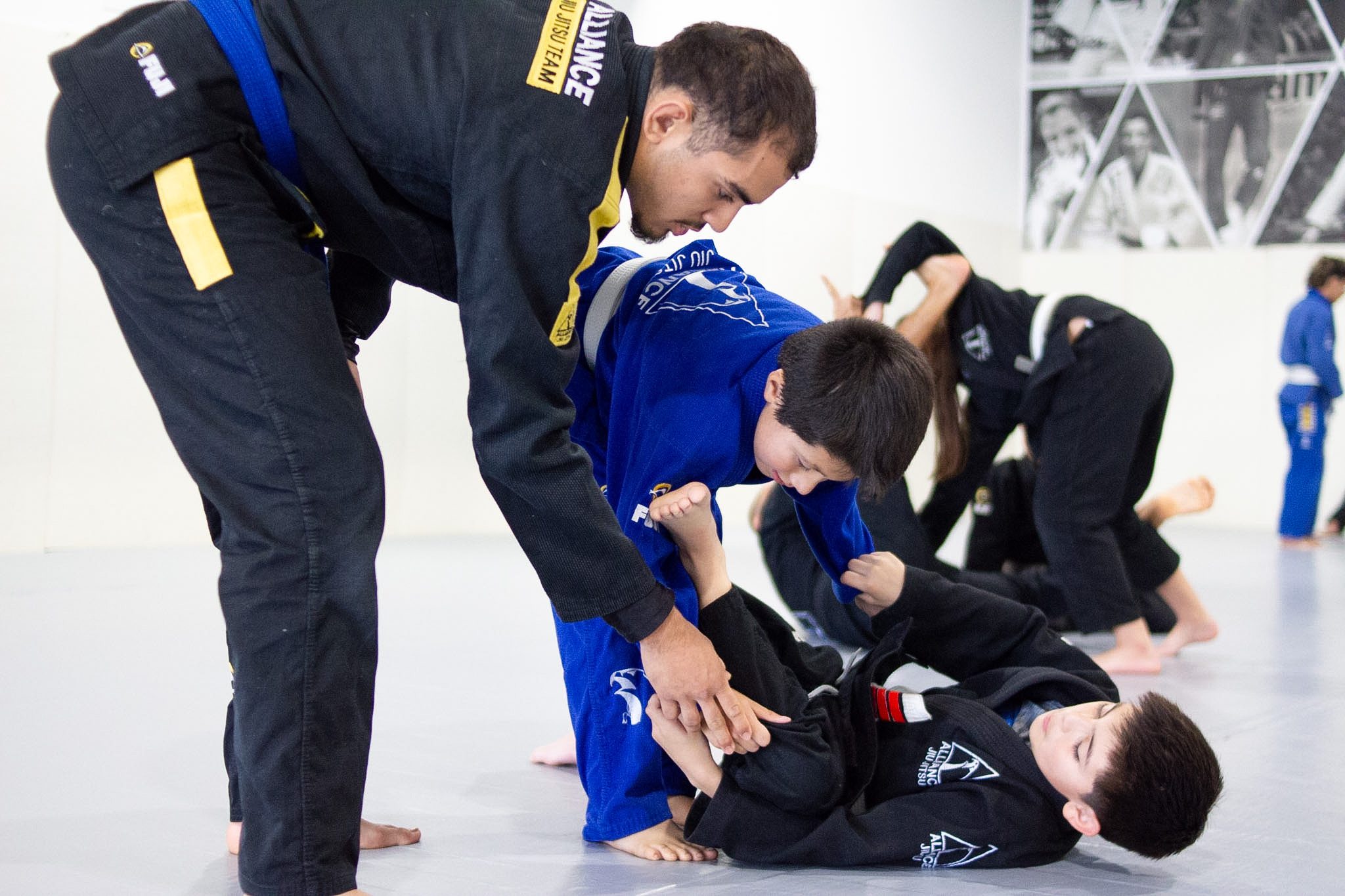 Instructor coaching a young student through a guard pass drill