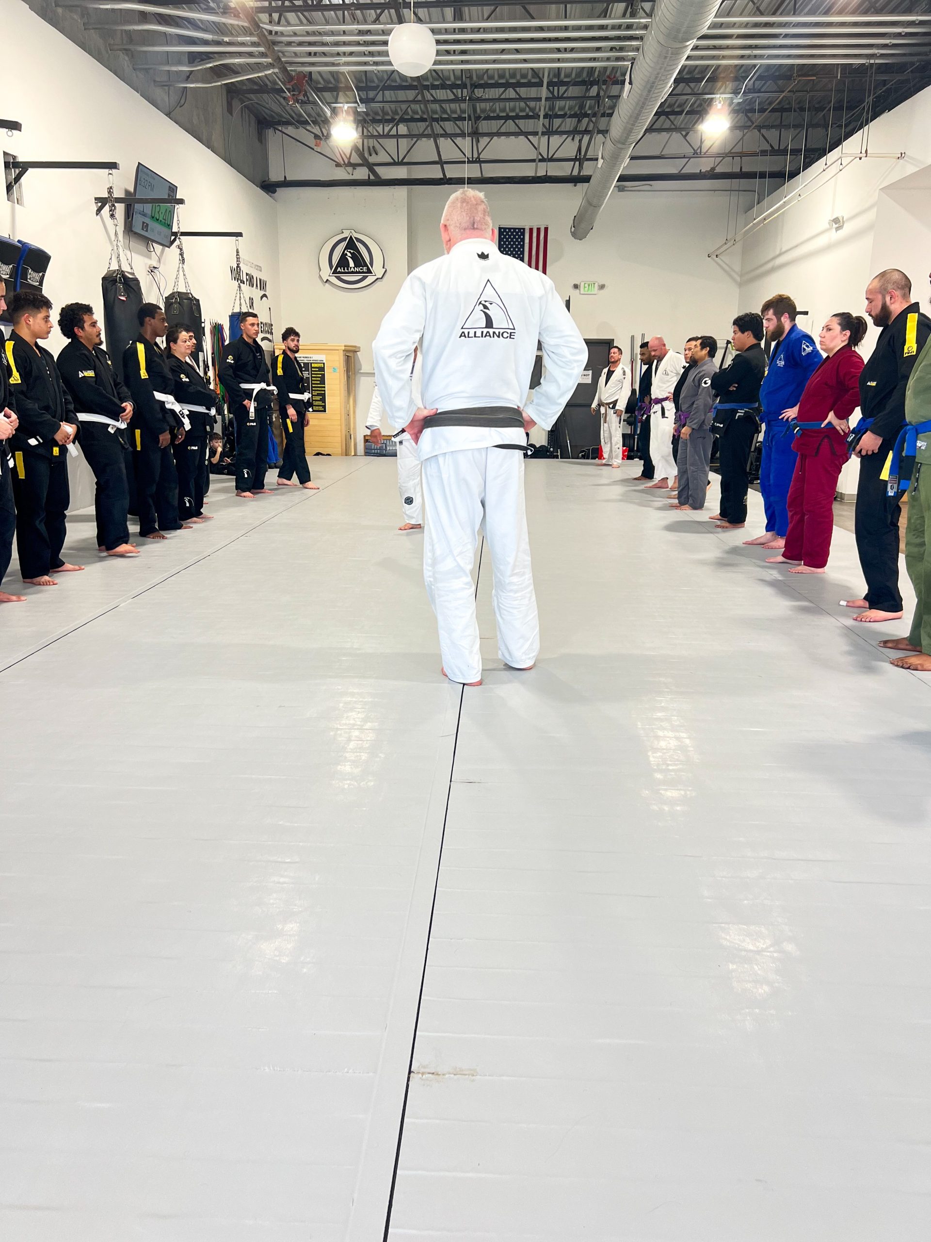 Alliance head instructor addressing a line of kids in black gis during class