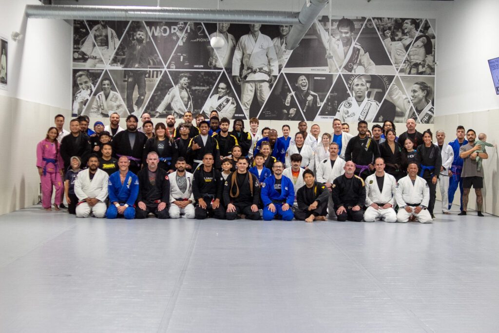 Brown belt in a black gi working side control during open mat at Alliance BJJ