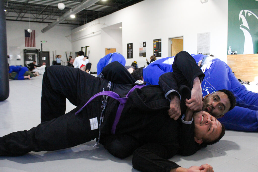 Purple belt securing back control during live rolling at Alliance BJJ Houston