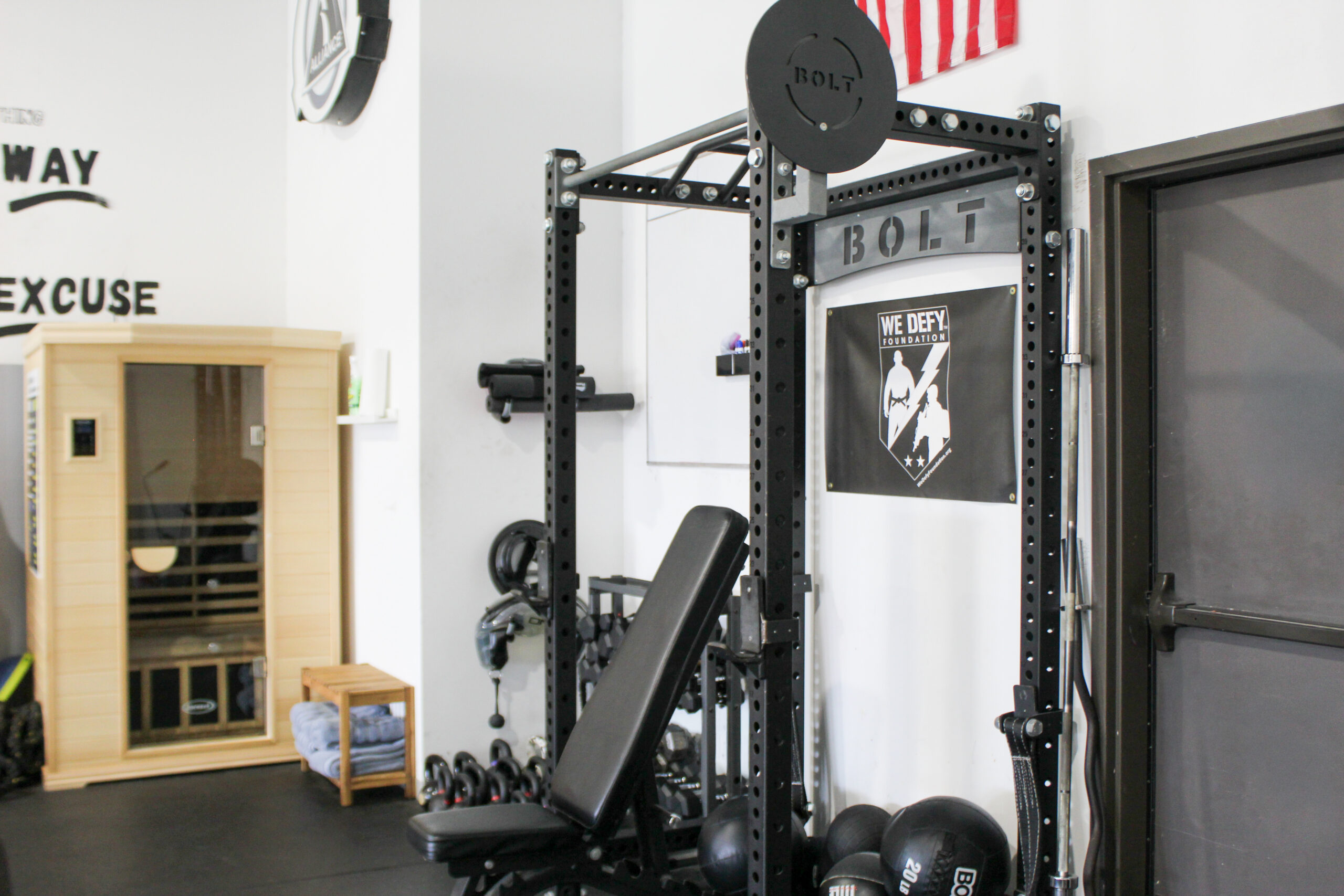Bolt power rack with adjustable bench, dumbbells, and kettlebells in the strength area