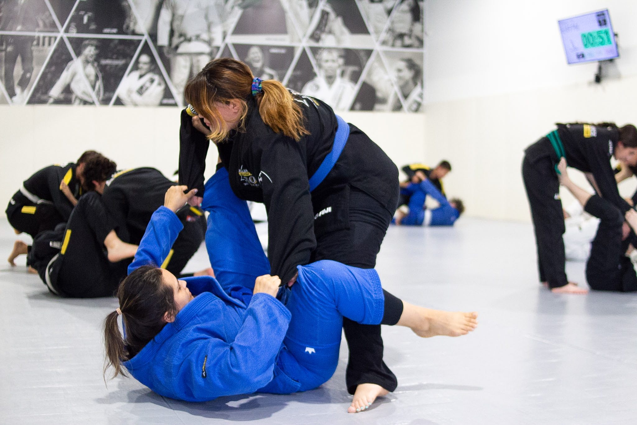 Two women working open guard passing during jiu-jitsu training