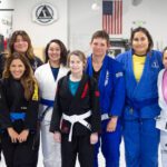 Group of eight women from Alliance BJJ Houston's women's class posing together