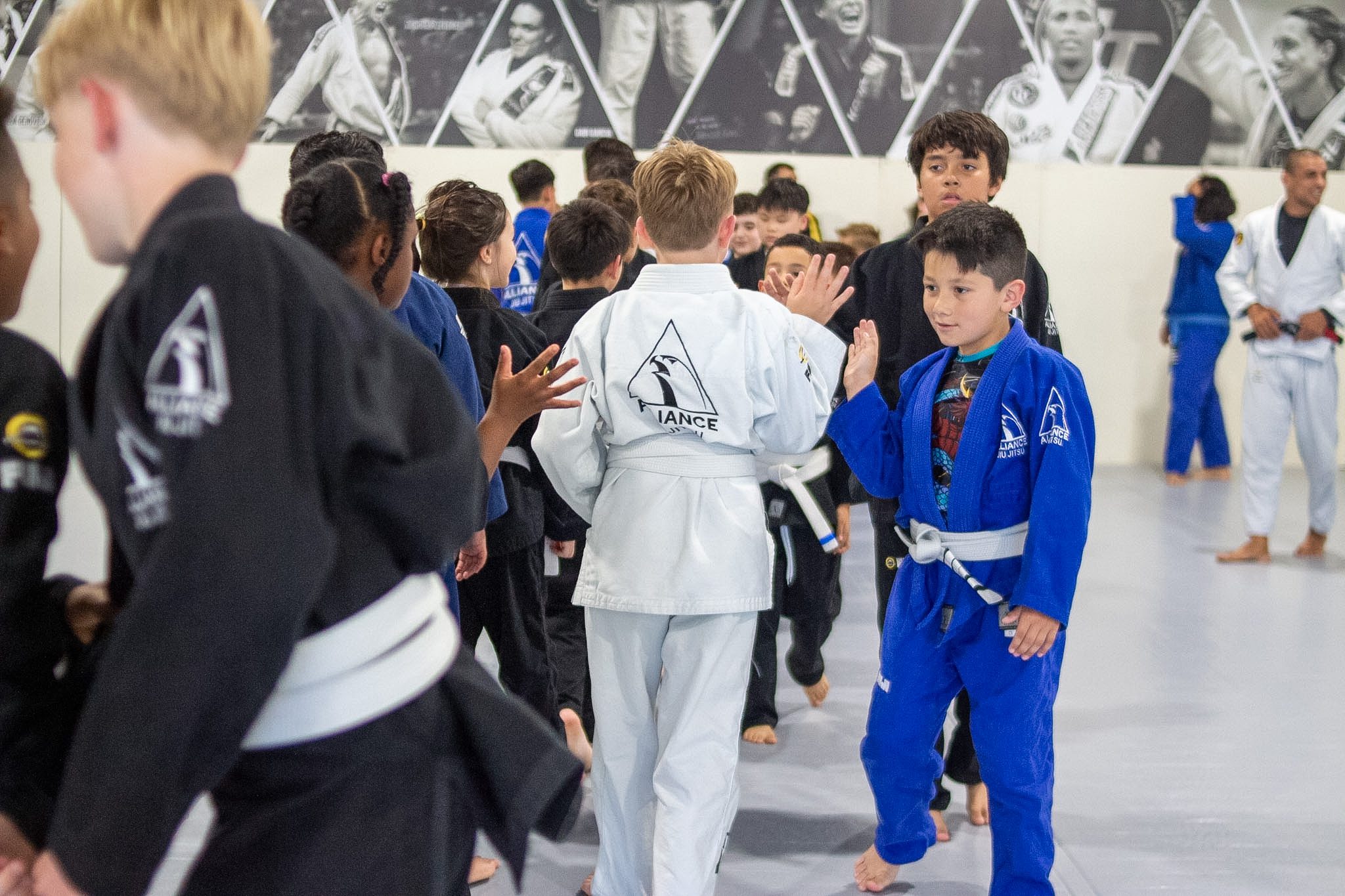 Young students high-five each other in a celebration tunnel after belt ceremony