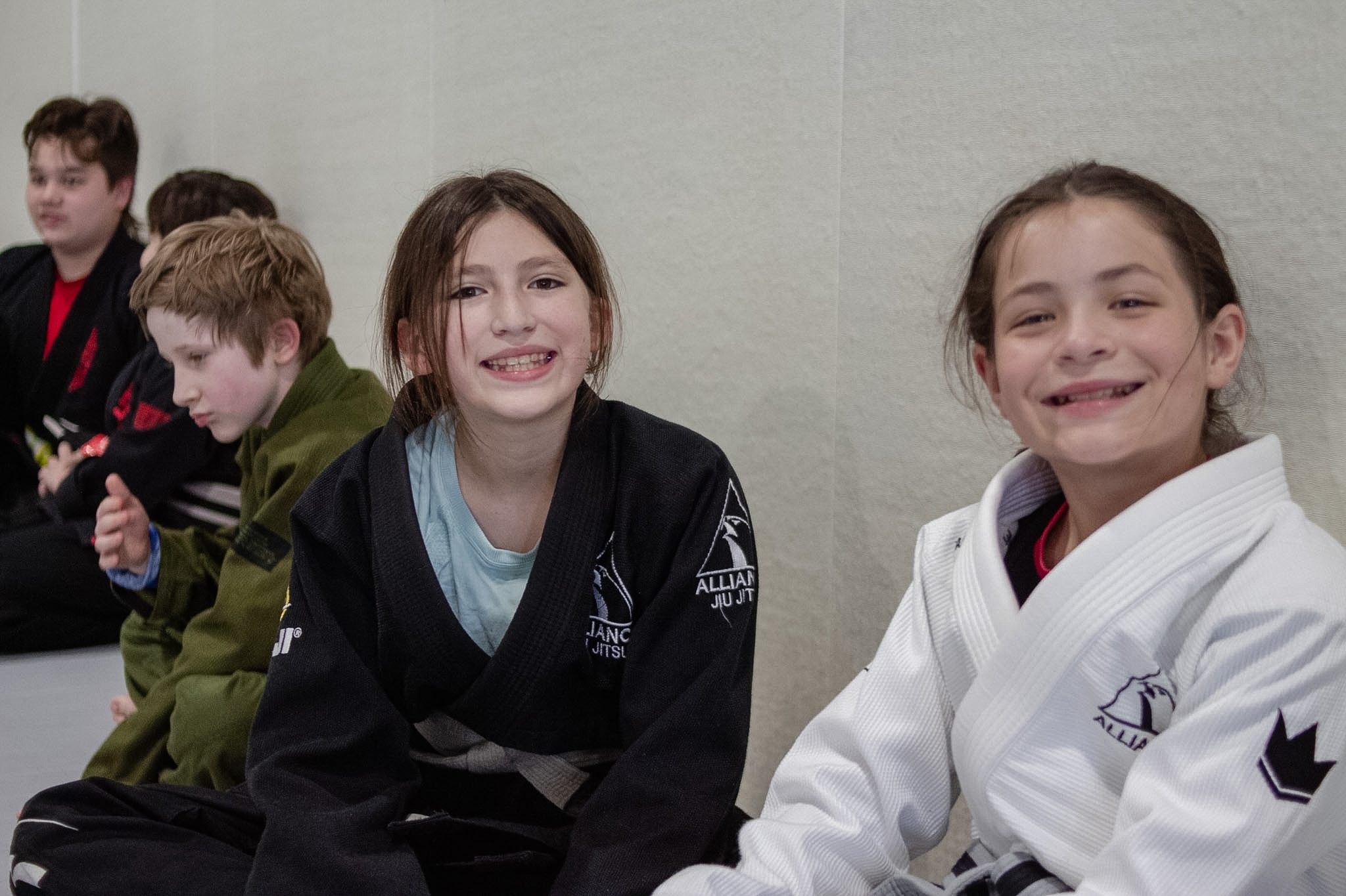 Two young students in black gis smile during the kids promotion night