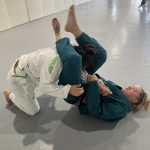 Woman controls her training partner from guard during a women's jiu-jitsu self-defense class