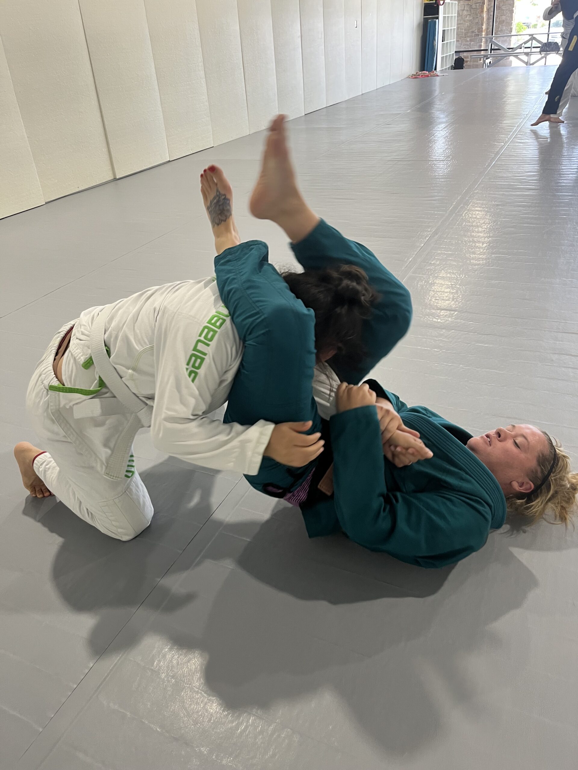 Woman controls her training partner from guard during a women's jiu-jitsu self-defense class
