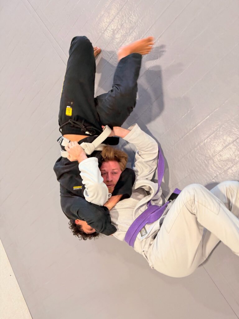 Purple belt attacks from guard during a live round at the Pearland academy