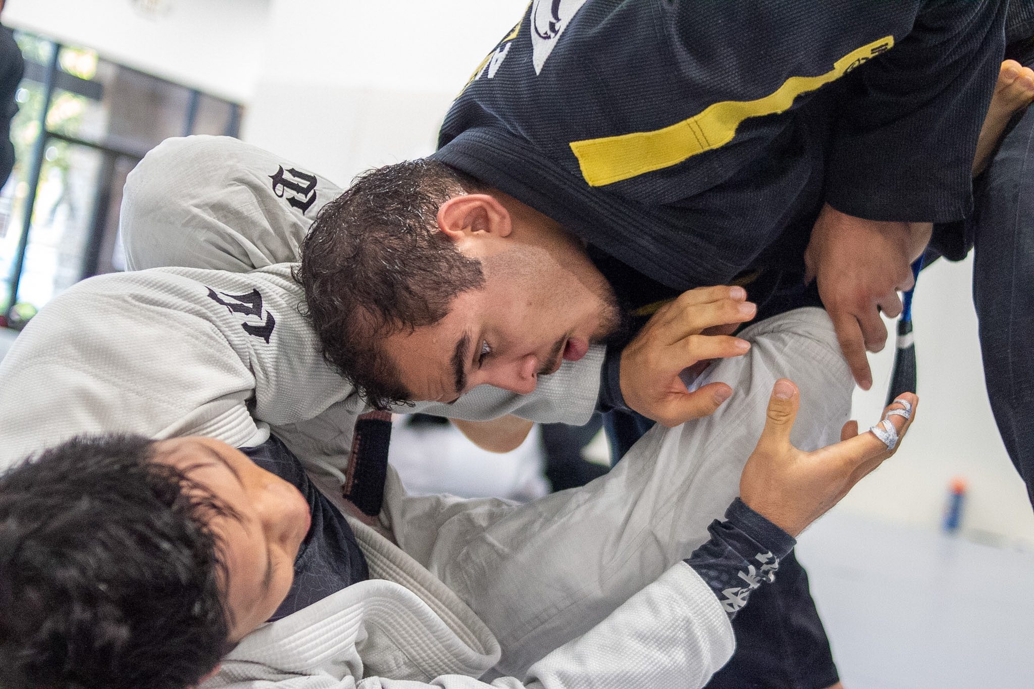 Adult students drilling close-range gi pressure with taped fingers on the mats