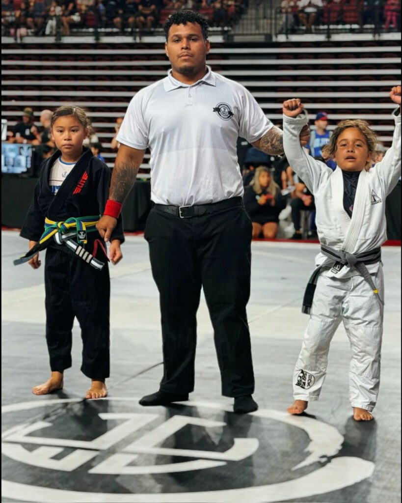 Referee raises Arden Luttmann hand after a Youth division win in the gi
