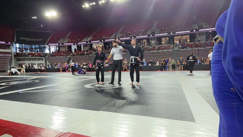 Hudson Hawkins has his hand raised after an Adults division gi match